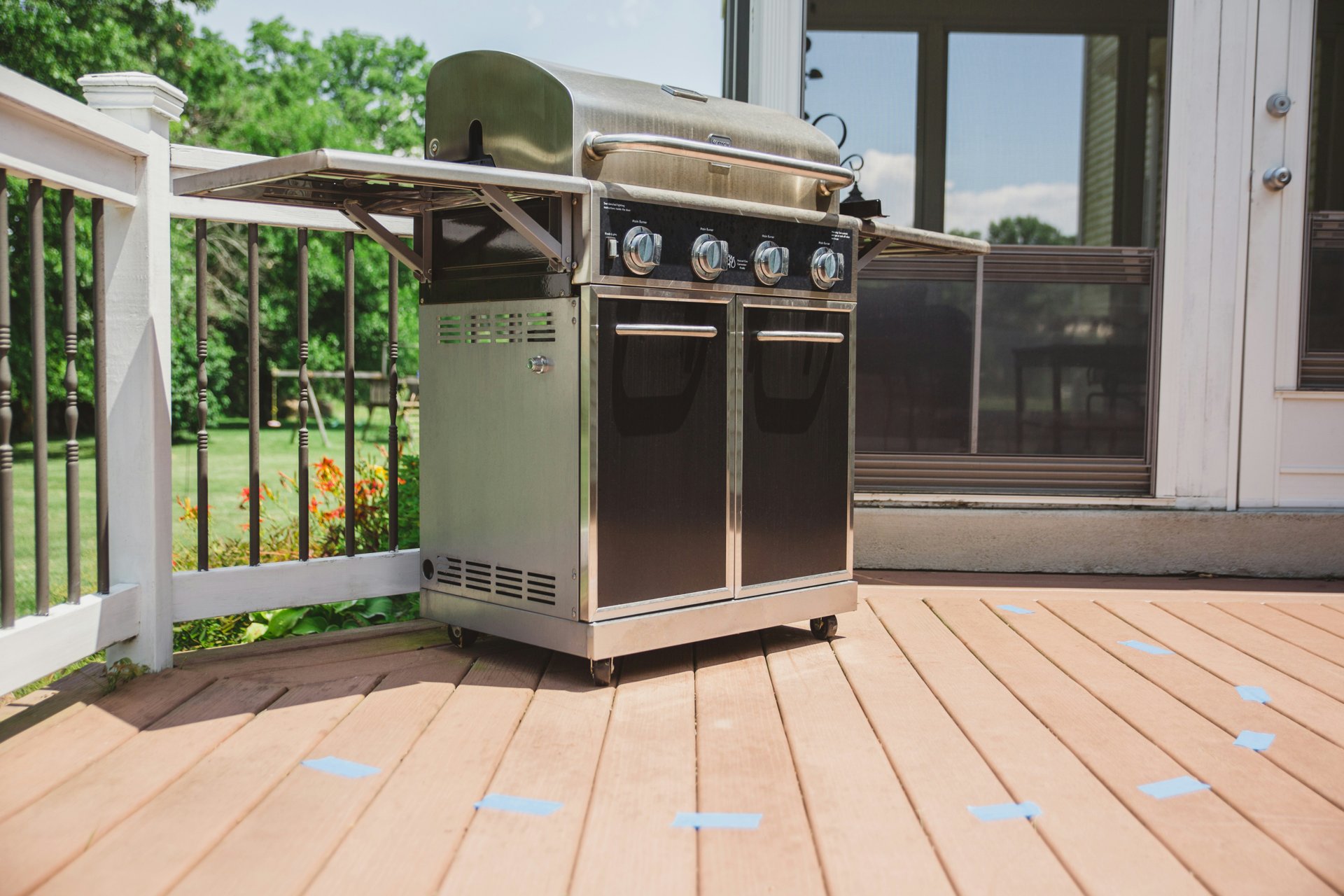 Stainless steel gas BBQ grill on a garden deck