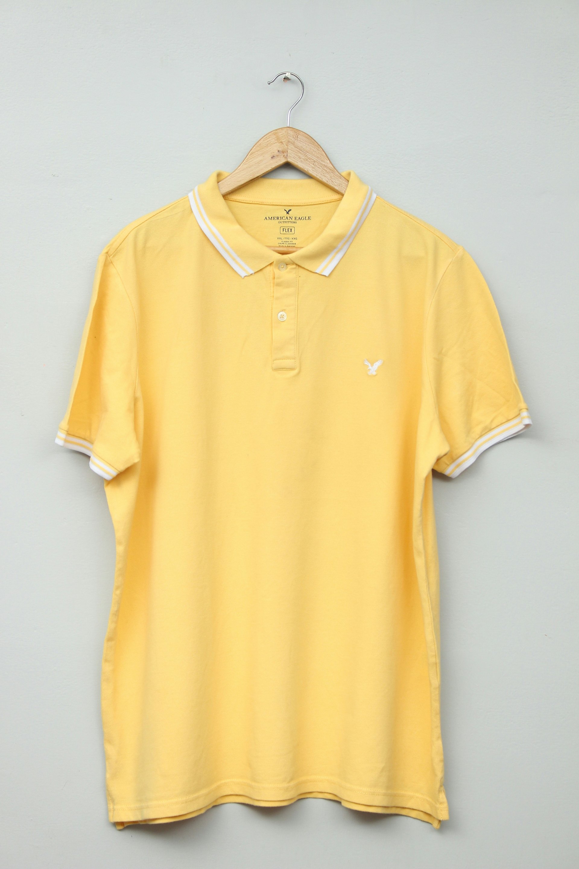 Navy blue polo shirt on wooden hanger