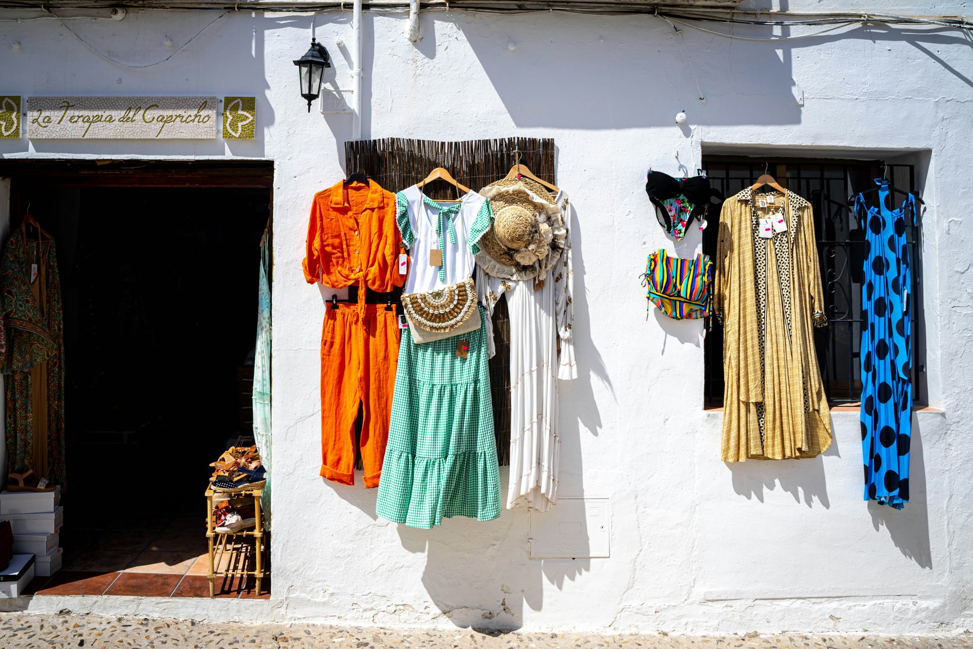 Bright summer fashion display with colourful dresses on hangers